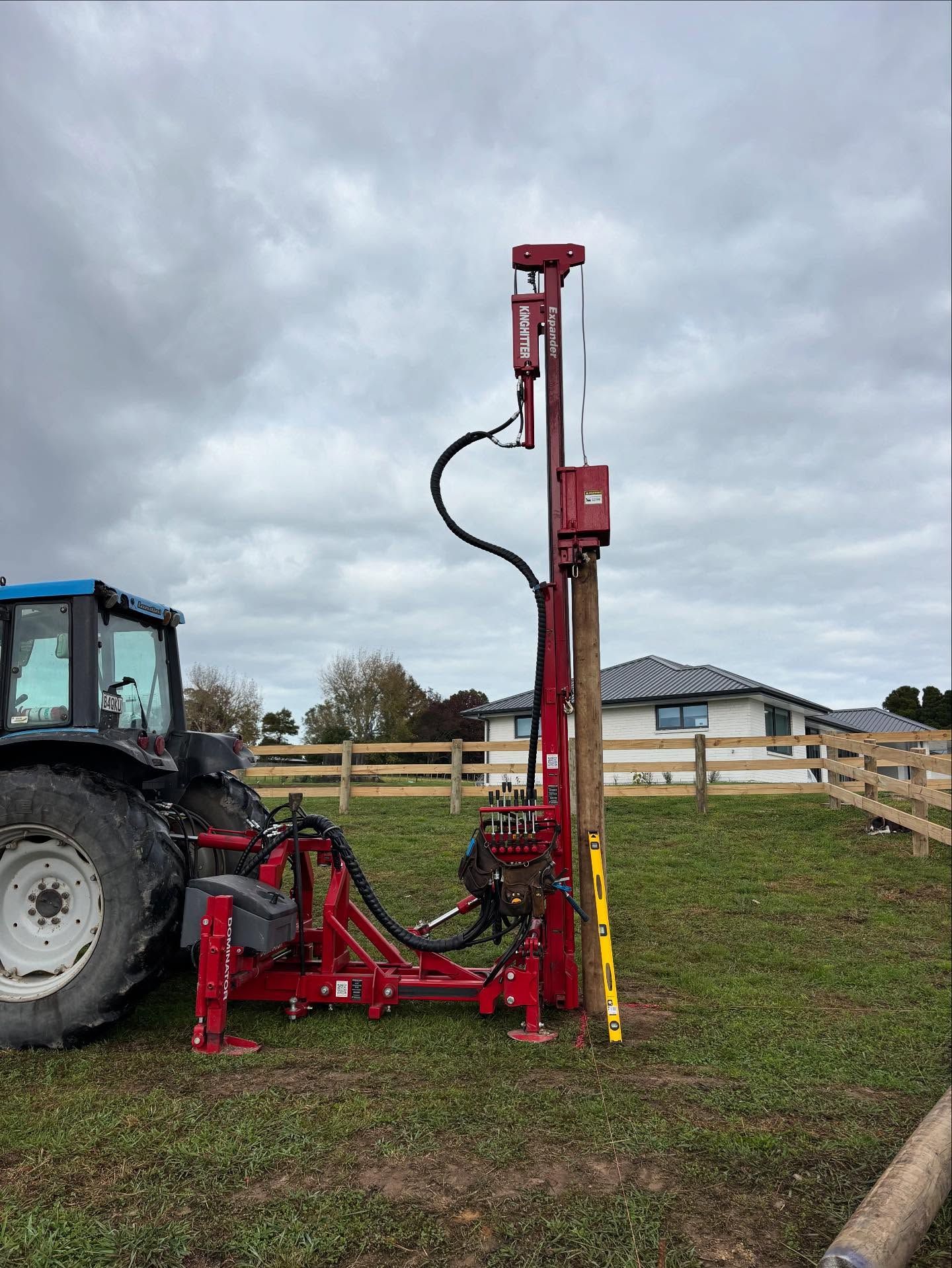 Tractor-mounted hydraulic post driver on a Rodney job